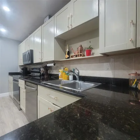 a kitchen with stainless steel appliances a sink dishwasher stove and cabinets