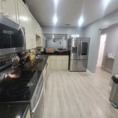 a kitchen with a sink and stainless steel appliances