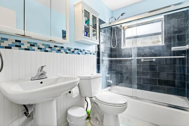 a bathroom with a sink a toilet and shower