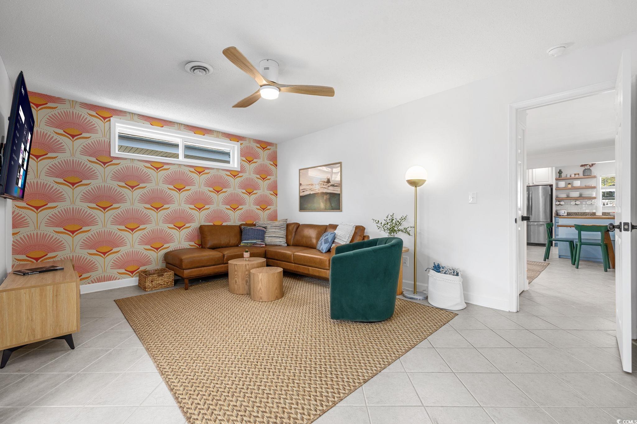 104 Ash Street North Myrtle Beach, SC 29582 - Photo 13 of 39 Living area with wallpapered walls, ceiling fan, an accent wall, and light tile patterned flooring