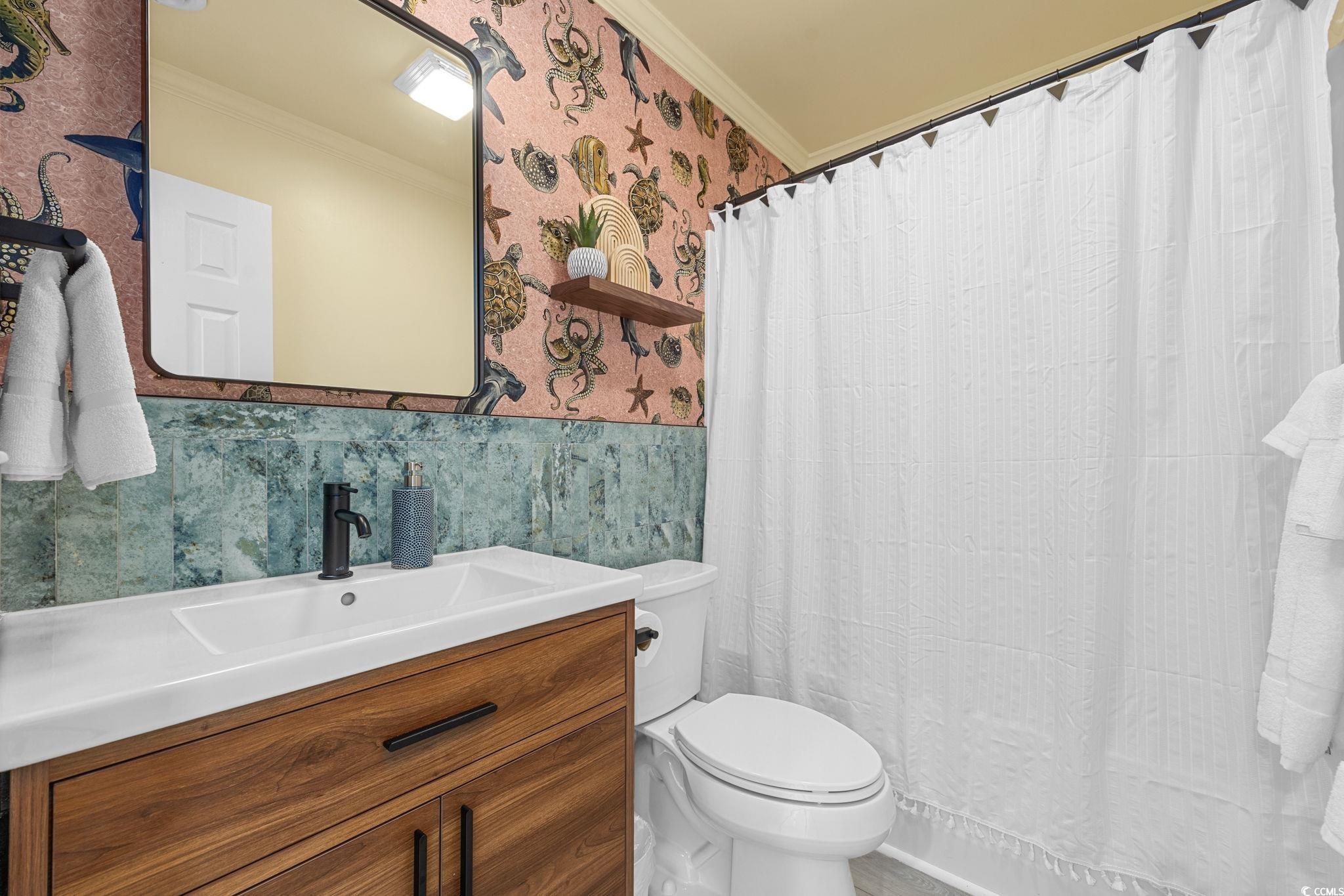 104 Ash Street North Myrtle Beach, SC 29582 - Photo 19 of 39 Full bath featuring wallpapered walls, vanity, ornamental molding, curtained shower, and tile walls