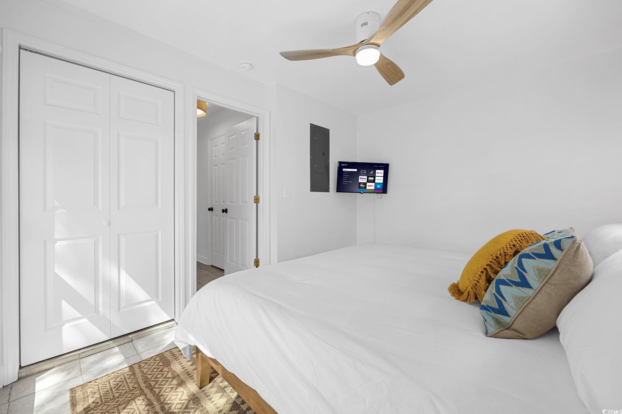 104 Ash Street North Myrtle Beach, SC 29582 - Photo 26 of 39 Bedroom with ceiling fan, light tile patterned floors, electric panel, and a closet