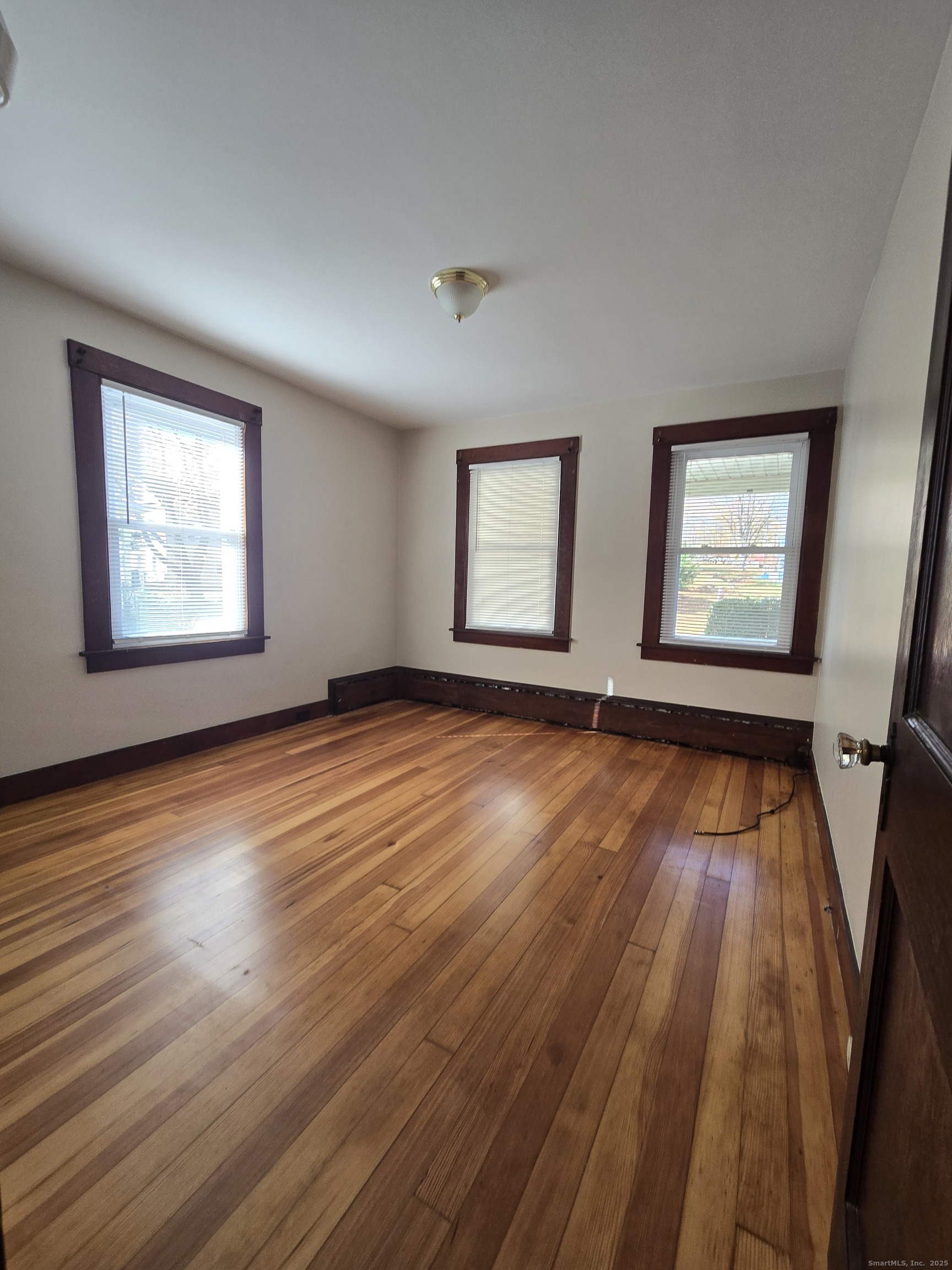 19 Downer Street Stonington, CT 06379 - Photo 3 of 13 a view of an empty room with wooden floor and windows