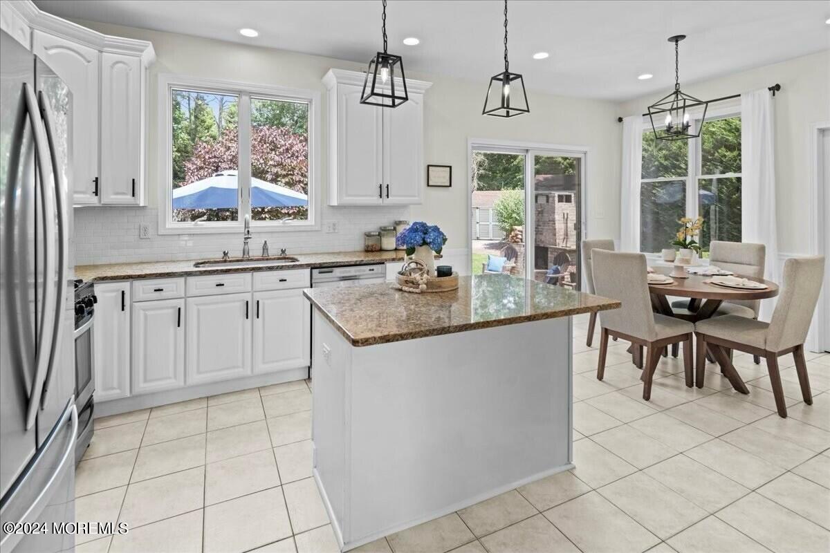 19 Popper Street Manahawkin, NJ 08050 - Photo 14 of 53 a kitchen with stainless steel appliances granite countertop a stove a sink a microwave and a dining table