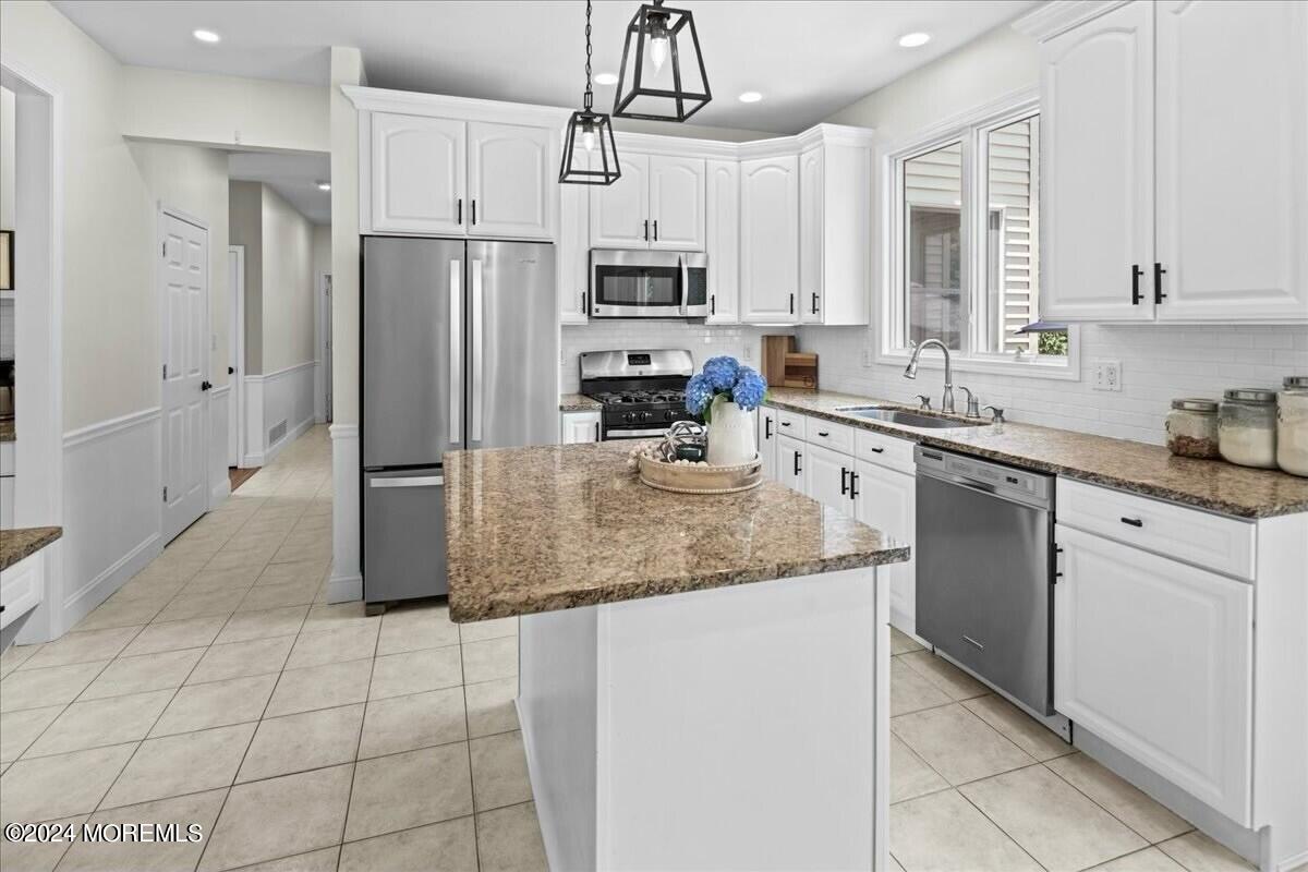 19 Popper Street Manahawkin, NJ 08050 - Photo 15 of 53 a kitchen with stainless steel appliances granite countertop a sink a stove a refrigerator a microwave and cabinets