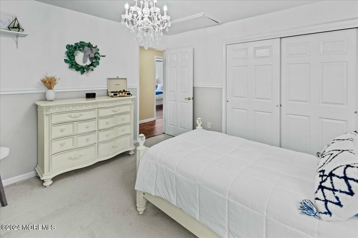 19 Popper Street Manahawkin, NJ 08050 - Photo 25 of 53 a bedroom with a bed and a chandelier