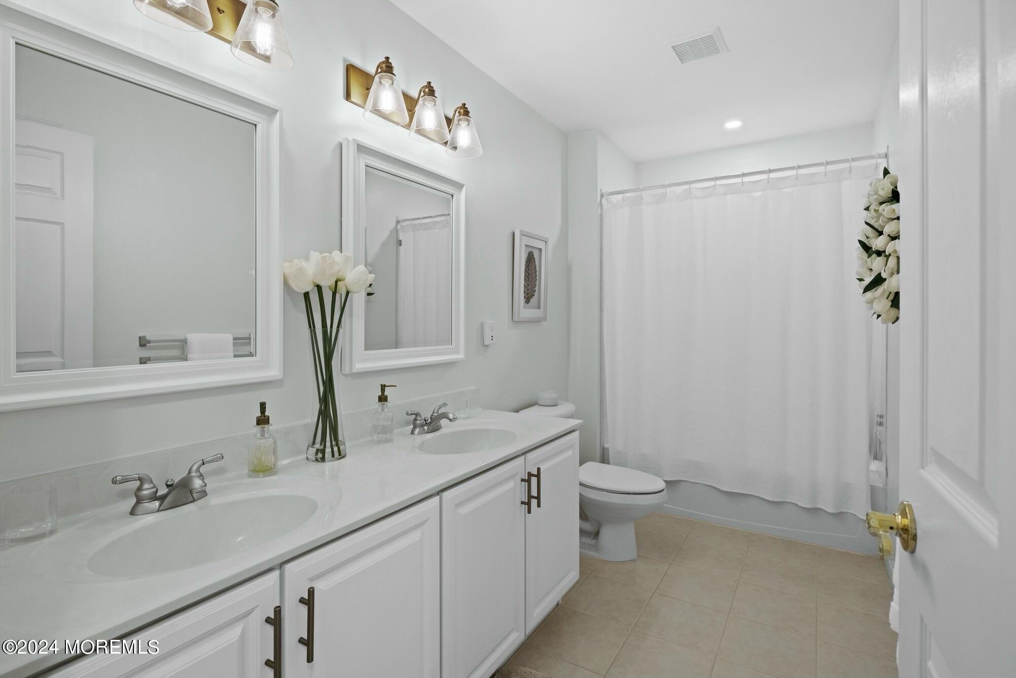 19 Popper Street Manahawkin, NJ 08050 - Photo 27 of 53 a bathroom with a double vanity sink and a mirror