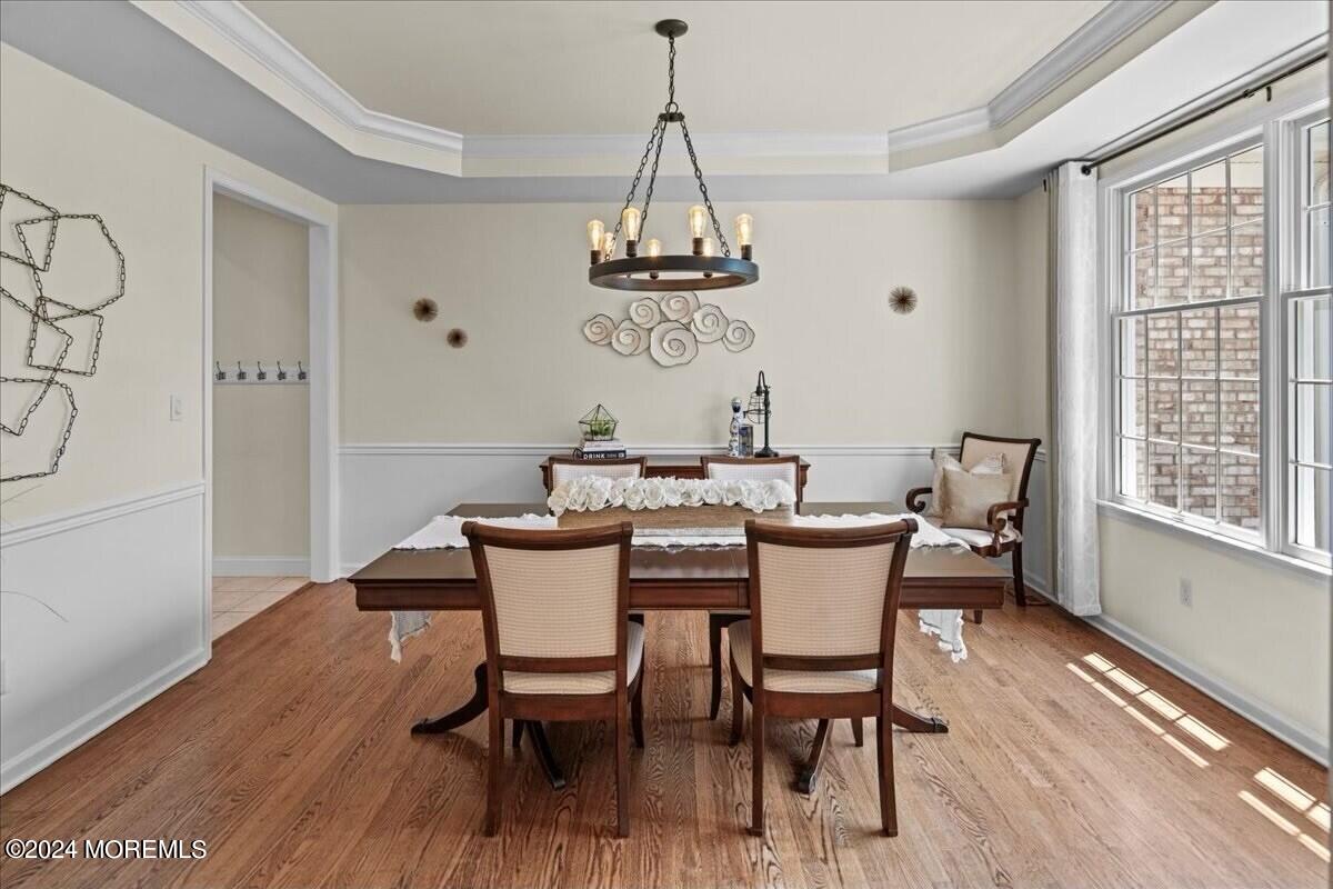 19 Popper Street Manahawkin, NJ 08050 - Photo 4 of 53 a dining room with wooden floor a chandelier a wooden table and chairs
