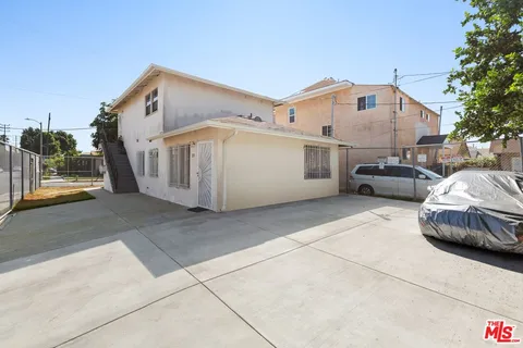 a white building with a large window and parking space