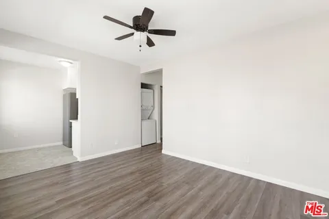 a view of a room with wooden floor and a ceiling fan
