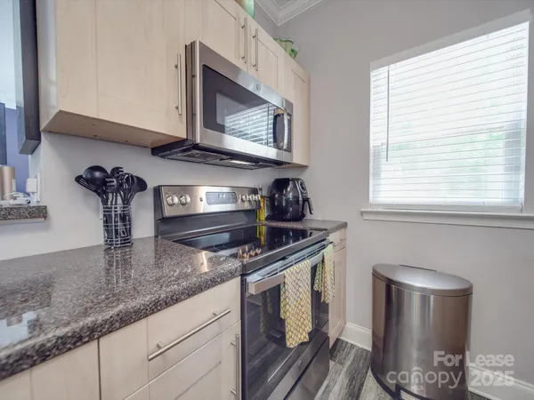 a kitchen with granite countertop a refrigerator stove and sink