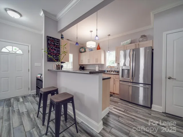 a kitchen with a refrigerator a sink and chairs