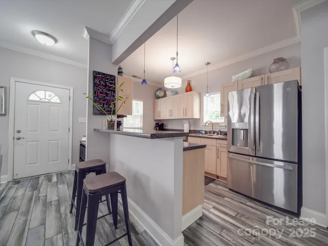 a kitchen with a refrigerator a sink and chairs