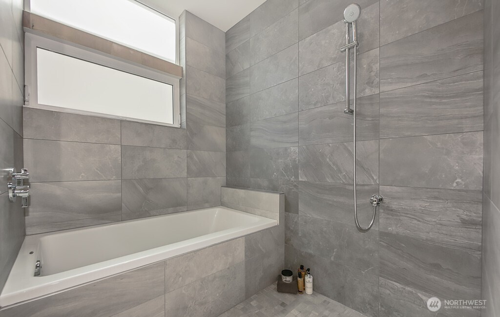 3516 Northeast 87th Street, Unit C Seattle, WA 98115 - Photo 14 of 18 a bath tub sitting next to a shower