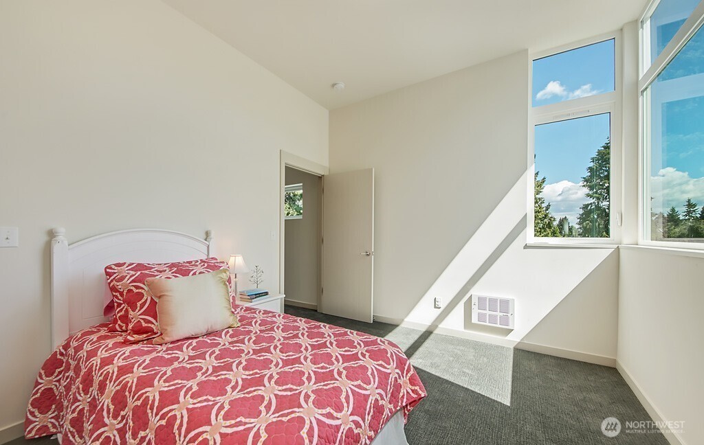 3516 Northeast 87th Street, Unit C Seattle, WA 98115 - Photo 7 of 18 a large bed sitting in a bedroom next to a window