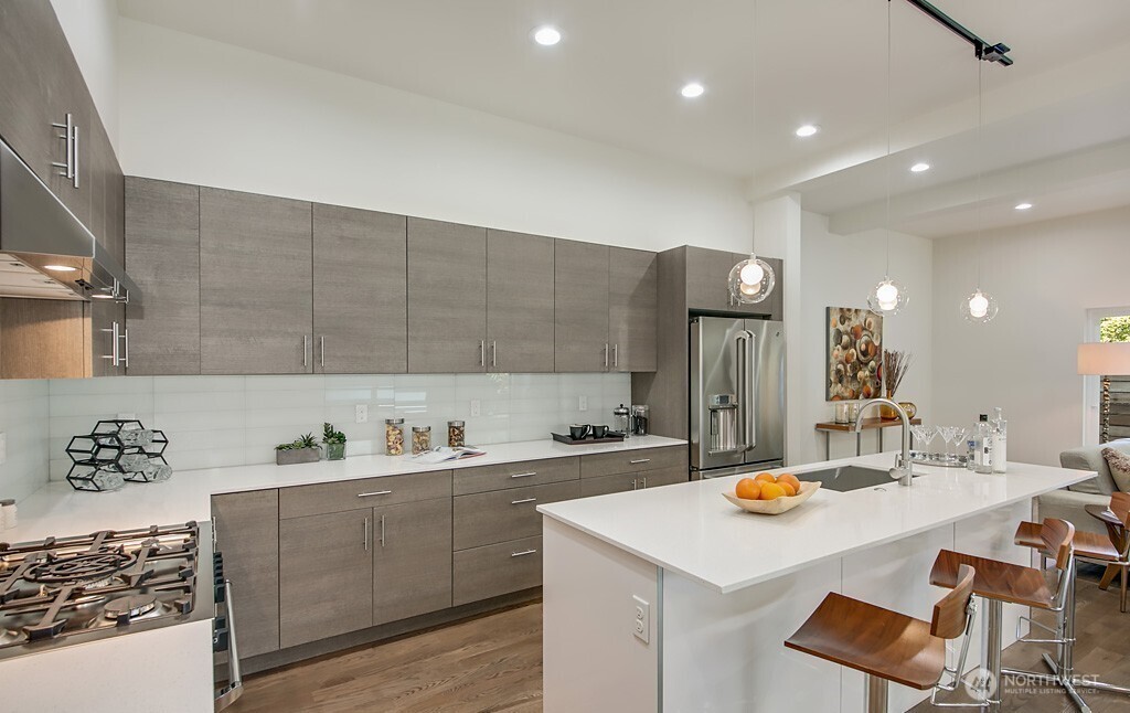 3516 Northeast 87th Street, Unit C Seattle, WA 98115 - Photo 9 of 18 a kitchen with a sink a stove and chairs