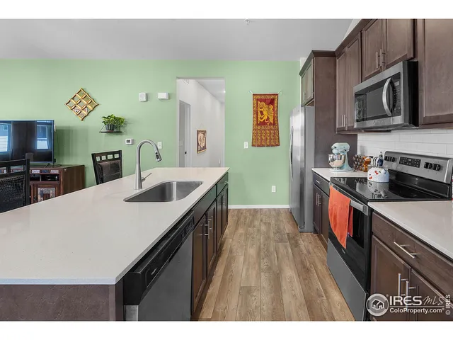 a kitchen with stainless steel appliances a sink a stove top oven a chimney cabinets and a counter top space