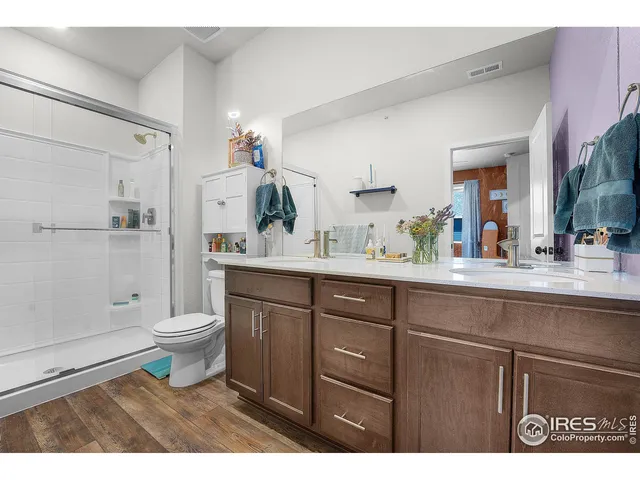 a bathroom with a sink a toilet a mirror and shower