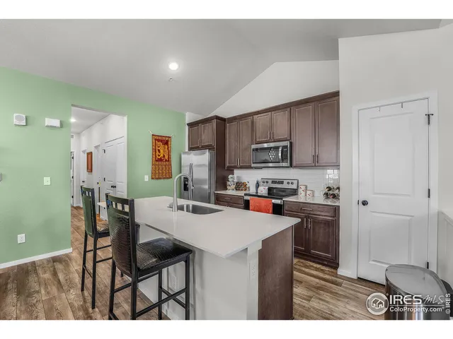 a kitchen with a dining table chairs and refrigerator