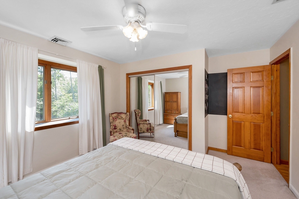 51 Tyler Road Townsend, MA 01469 - Photo 26 of 42 a bedroom with a large bed and a chandelier