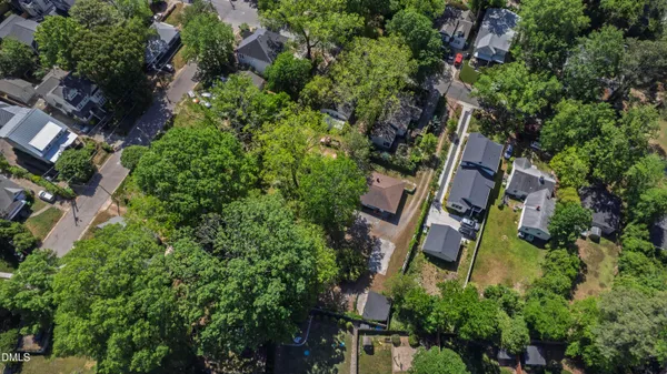 an aerial view of residential house with outdoor space and trees all around