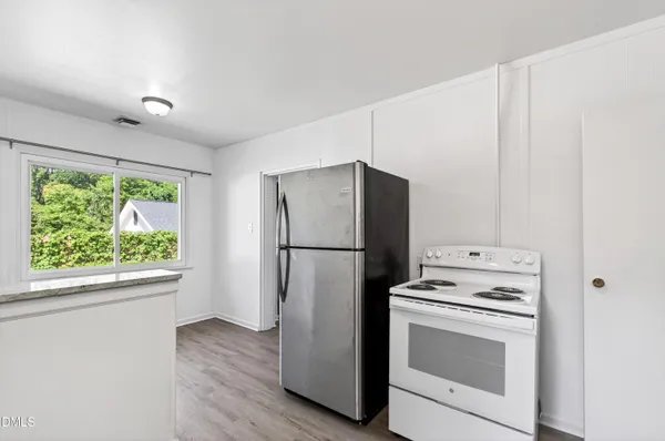 a kitchen with a stove a refrigerator and a window