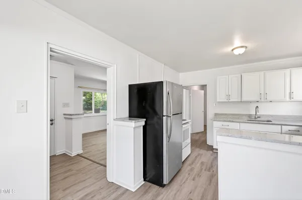a kitchen with a refrigerator sink and cabinets