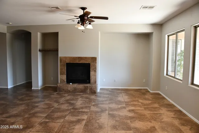 a view of an empty room with a fireplace and a window