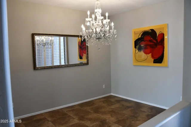 a view of a hallway with paintings on the wall and a potted plant
