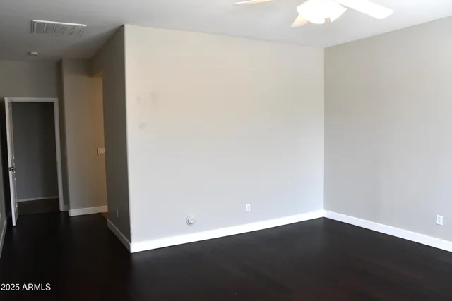 an empty room with wooden floor and door