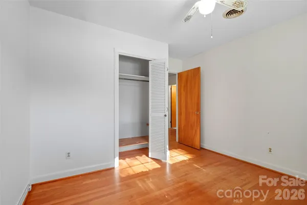 a bedroom with a bed a window and dresser