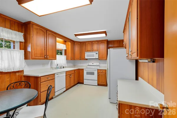 a kitchen with granite countertop a sink stove and cabinets
