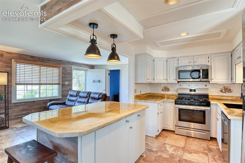 10970 Garrett Road Peyton, CO 80831 - Photo 11 of 50 a kitchen with stainless steel appliances granite countertop a sink a stove and a refrigerator