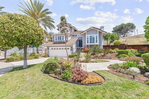 a front view of a house with a yard and fountain