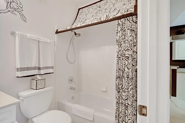 a bathroom with a shower curtain and a toilet