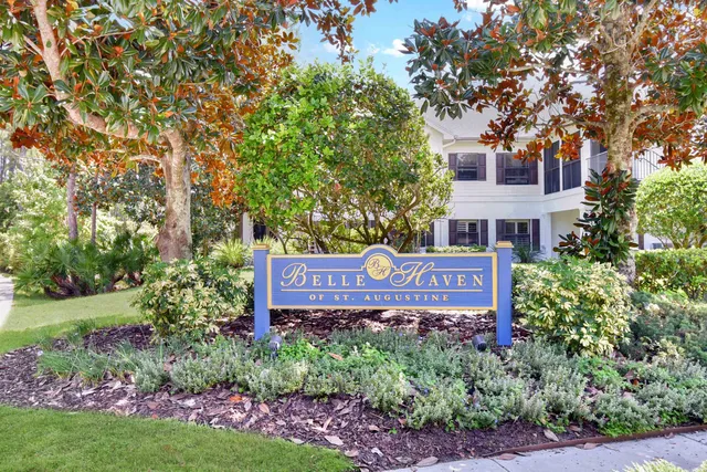 a big white house with a yard and plants