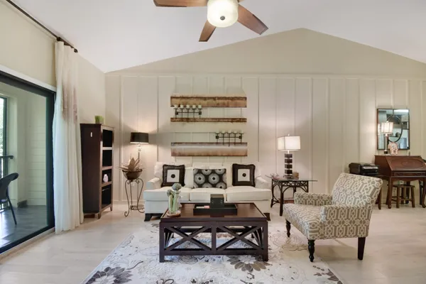 a living room with furniture a dining table and a refrigerator