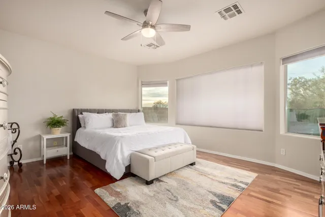 a spacious bedroom with a large bed and a chandelier
