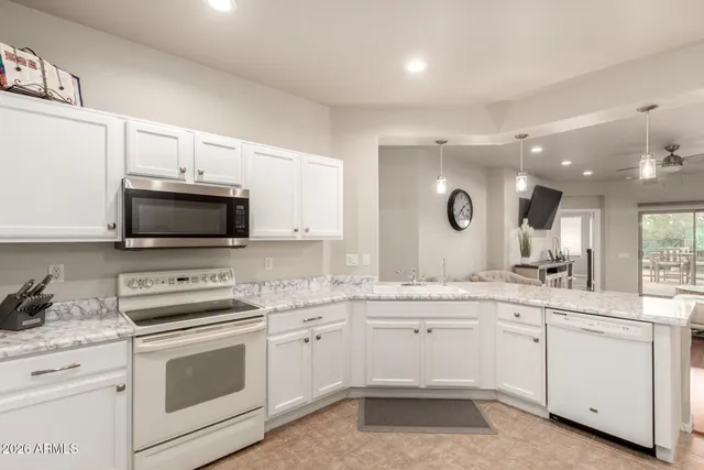 a kitchen with white cabinets appliances and sink