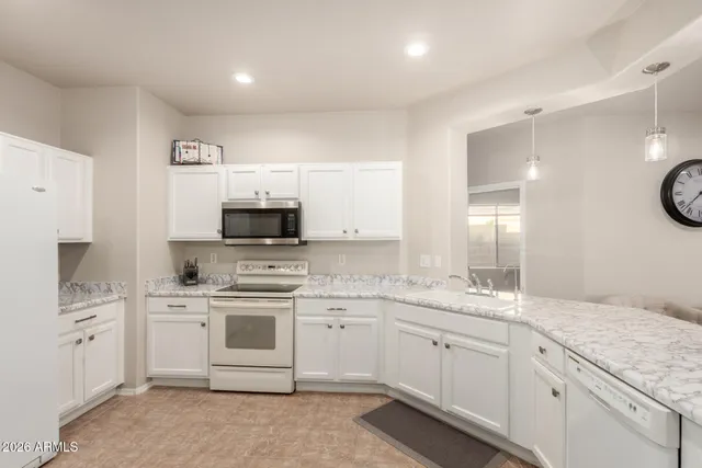 a kitchen with a sink stove and white cabinets
