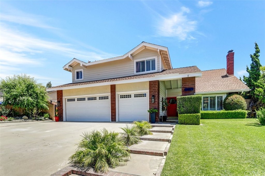 a front view of a house with a yard and potted plants