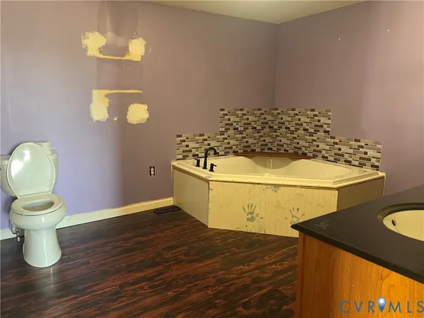 a kitchen with a sink and wooden floor