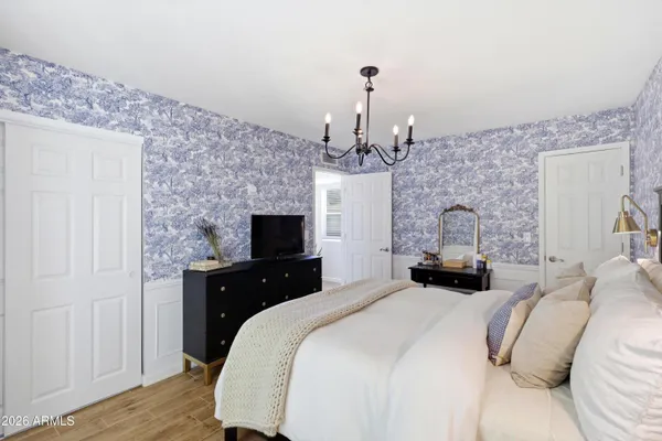 a bedroom with a bed and a chandelier