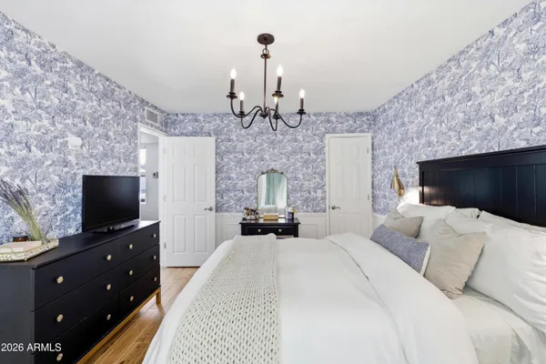 a bedroom with a bed and a flat tv screen on a dresser