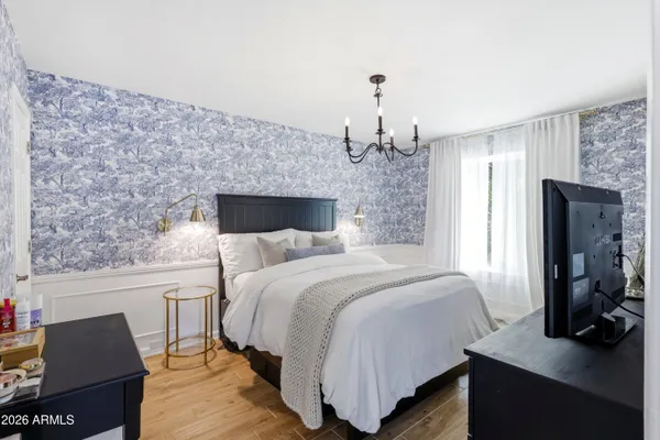 a bedroom with a bed and wooden floor