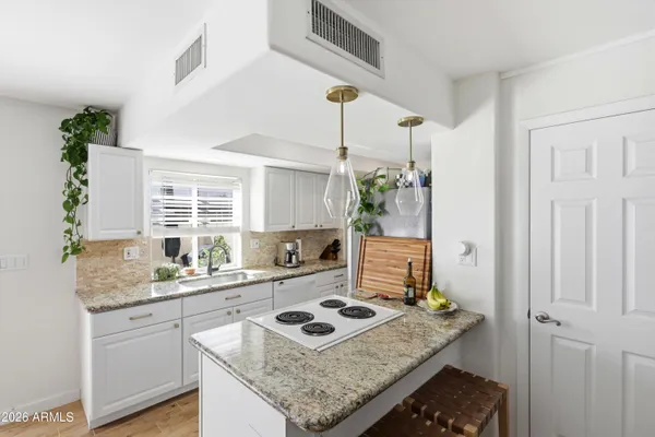 a kitchen with a stove a sink a refrigerator and a window