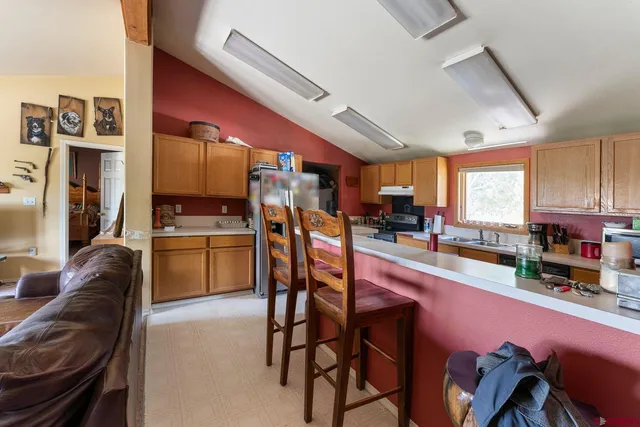 a kitchen with stainless steel appliances kitchen island granite countertop a table chairs microwave and sink