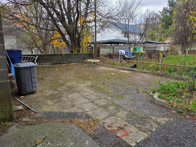 a backyard of a house with barbeque oven and a fountain