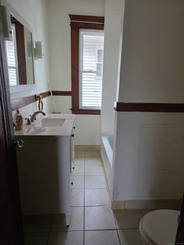 a bathroom with a granite countertop sink toilet and mirror