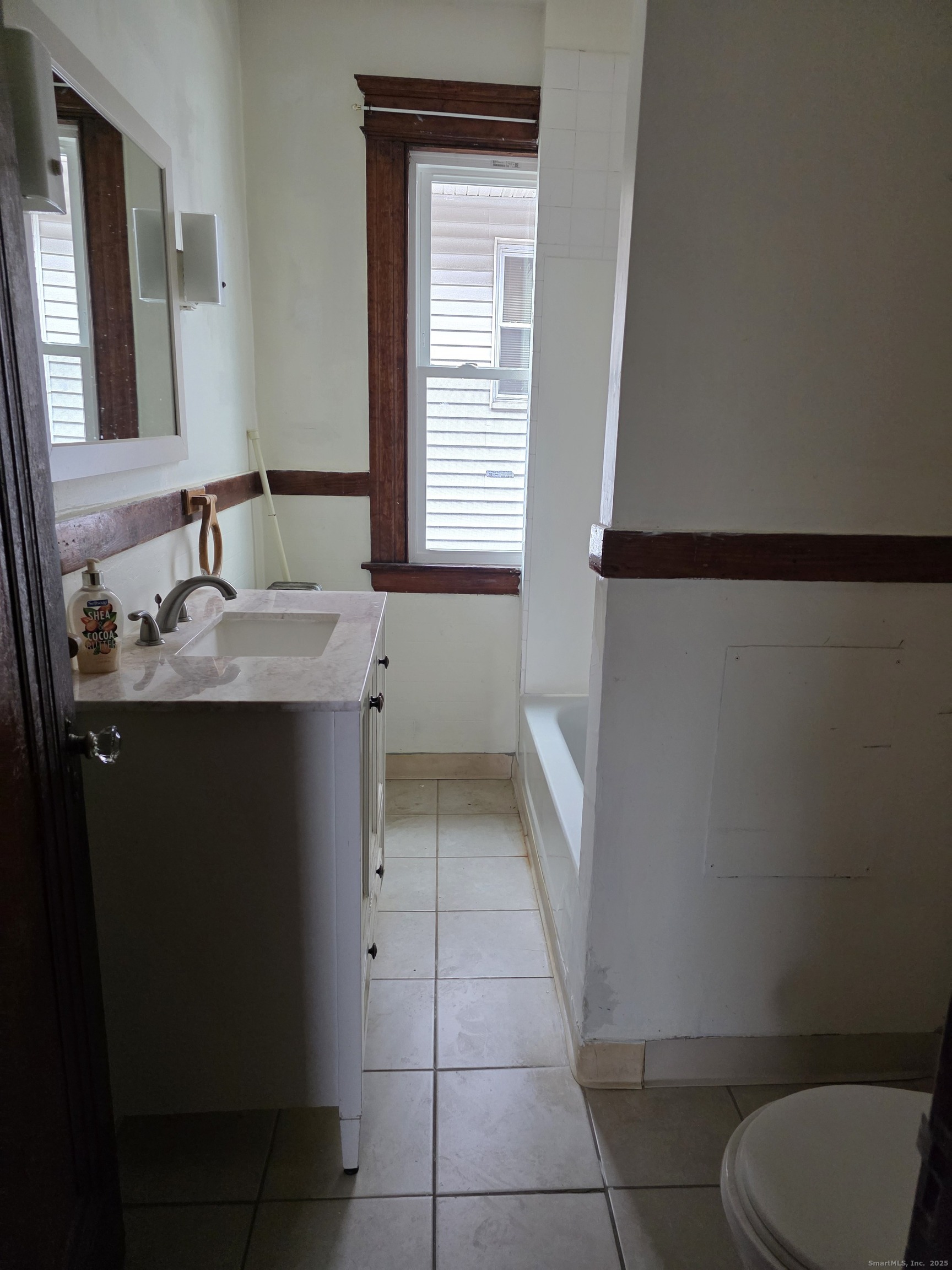 166 Oak Street, Unit 2 Waterbury, CT 06704 - Photo 6 of 13 a bathroom with a granite countertop sink toilet and mirror